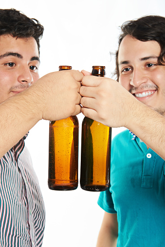 cheer two young man with beer bottle isolated on white