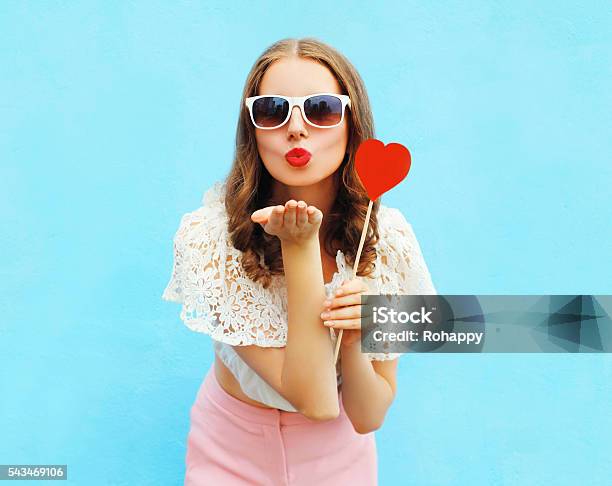 Woman With Red Heart Lollipop Sends Air Kiss Over Stock Photo - Download Image Now - Human Lips, Kissing, Summer