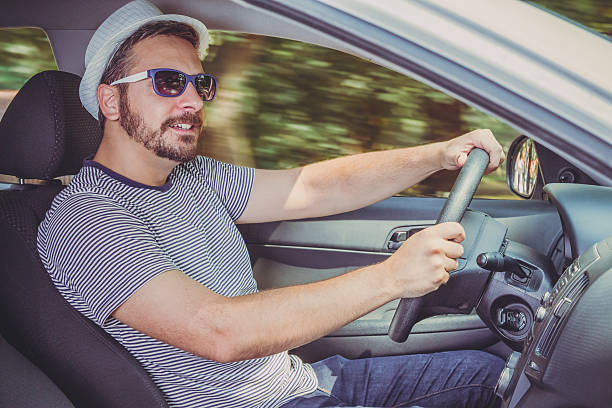 istock Side view of young man driving a car 543469992
