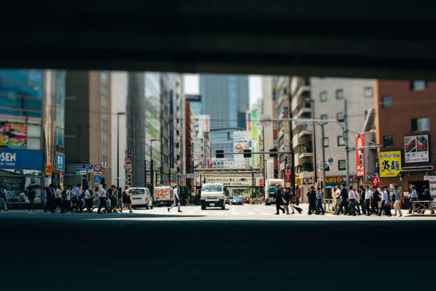 A large group of people crossing a crosswalk in Japan.