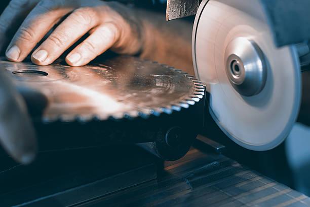 Sharpening Circular Saw, worker sharpens a circular saw blade Sharpening Circular Saw, worker sharpens a circular saw blade sharpening photos stock pictures, royalty-free photos & images