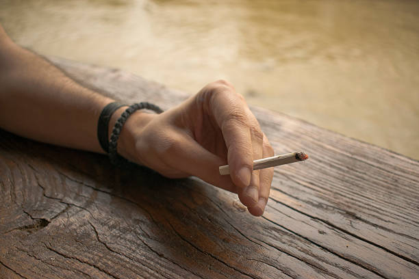 istock Man hand holding a cigarette with smoke 543472966