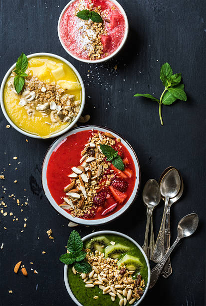 istock Healthy summer breakfast concept. Colorful fruit smoothie bowls with nuts 543473416