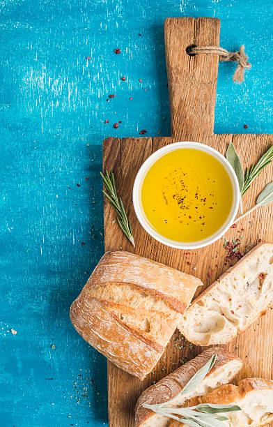 mediterrane snacks. olivenöl, kräuter und in scheiben geschnittenes ciabattabrot - mediterranean cuisine mediterranean culture food bread stock-fotos und bilder