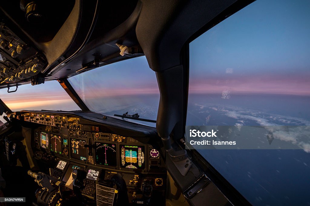 Jet flightdeck sunset view interior view from the cockpit of a jet airliner, sunset on the horizon Cockpit Stock Photo