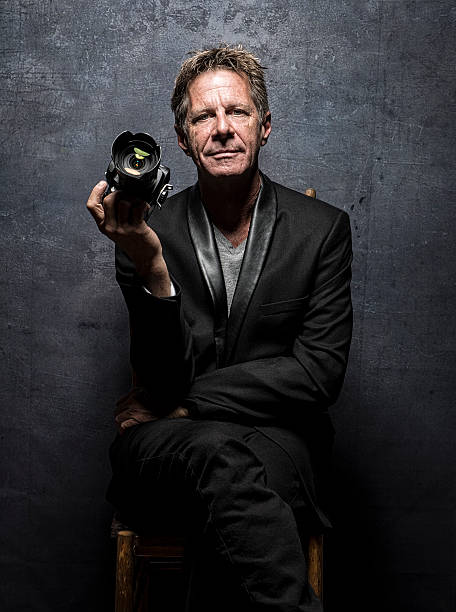 istock Male Celebrity In Suit Photographer Posing With His Camera 543476984