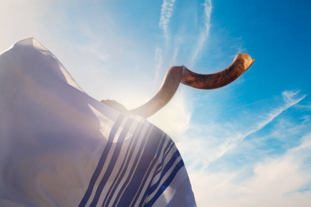 Jewish man blowing the Shofar in Yom Kippur Jewish man blowing the Shofar against blue sky religious celebration audio stock pictures, royalty-free photos & images