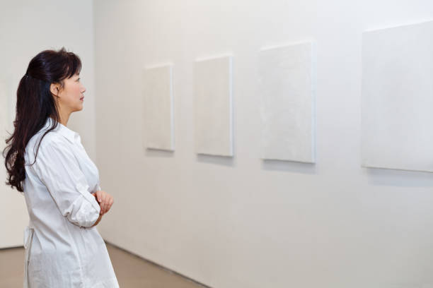 istock One woman looking at white frames in an art gallery 543479564