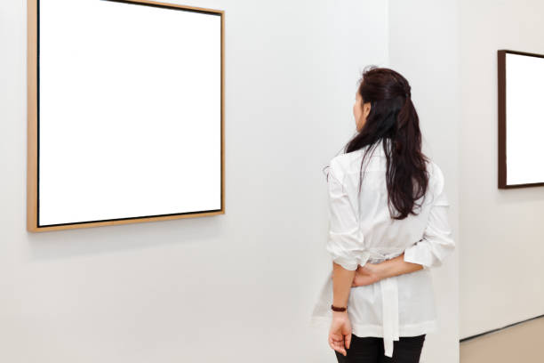 istock One woman looking at white frames in an art gallery 543479592