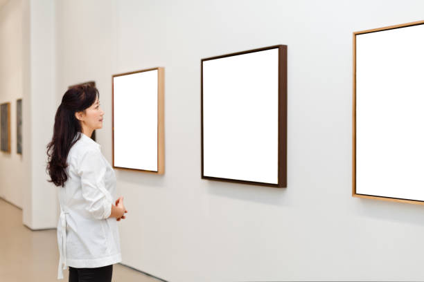 istock One woman looking at white frames in an art gallery 543479614