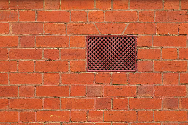 Closeup background texture photo of red brick wall with air vent, ventilation