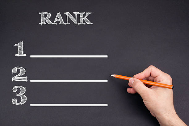 Hand with a white pencil writing: Rank blank list stock photo