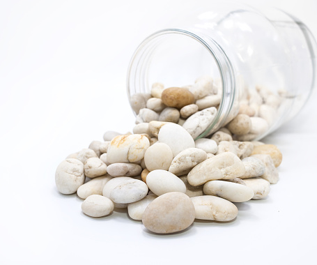 Canned pebble. Glass jar with sea pebbles isolated on white bacground.Glass jar with sea pebbles isolated on white bacground.