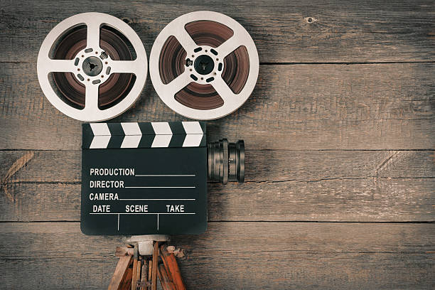 Old movie camera Old movie camera, consisting of a tripod, lens, film reels and clapperboards vintage video camera stock pictures, royalty-free photos & images