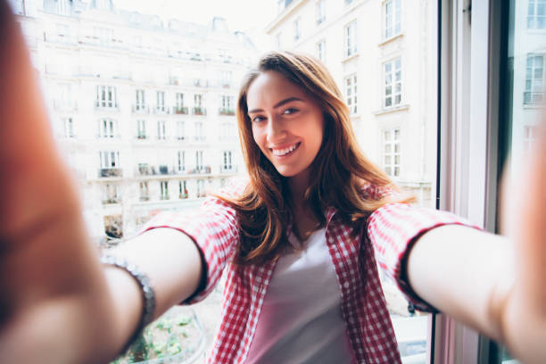 istock Young woman holding camera and making selfie 543558226