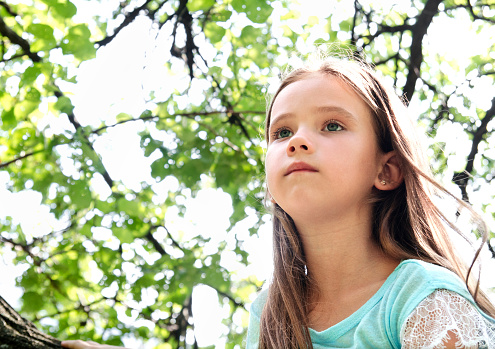 Cute little girl in looking away in summer day outdoor