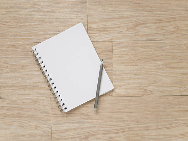 istock notebook  and pencil on wood floor 543565214