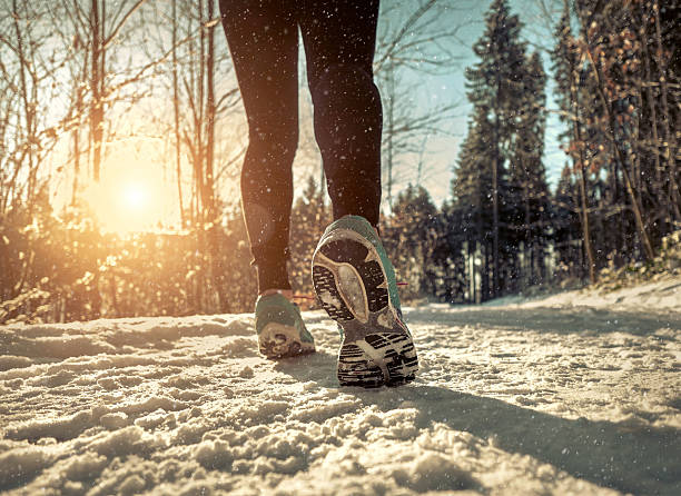 istock Woman Running at snowly winter under sunlight. 543566320