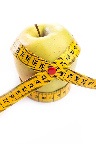 istock Fresh and green organic apple with metering tape on white 543566488