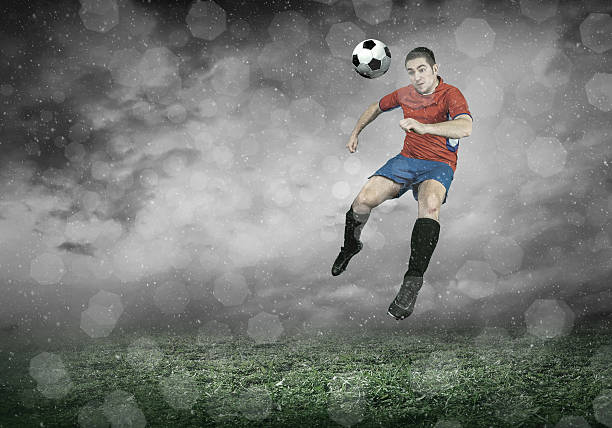 istock Football player with ball in action under sky with clouds 543566536