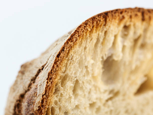 Detail image of one piece of bread. Sharp focus and narrow deep of field. Traditional sourdough bread loaf. Rustic recipe. Horizontal studio shot from a DSLR camera.