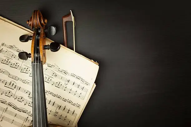 Photo of Old violin on dark wooden table