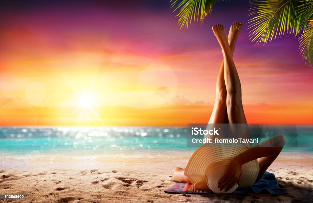 Woman In Relaxation On Tropical Beach At Sunset Girl On Sand In Beach At Sunset With Palm Tree Sun Tan Stock Photo