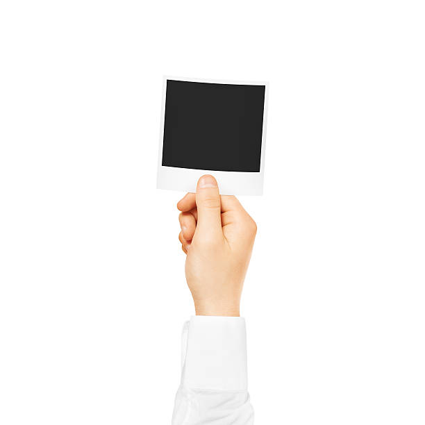 istock Hand holding blank photo frame mockup. Empty old photography 543569858