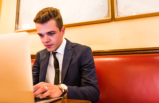 A business professional working on his laptop from a cafe in Paris, France.