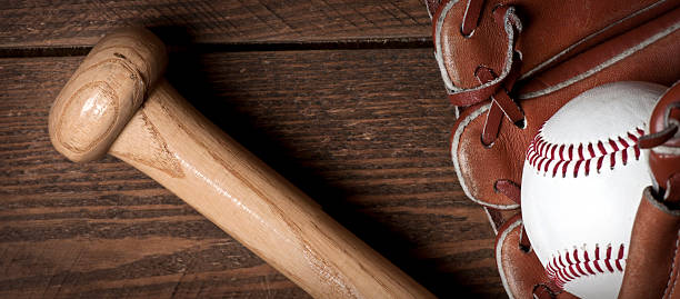 istock Baseball ball, glove and bat on wooden table 543573750