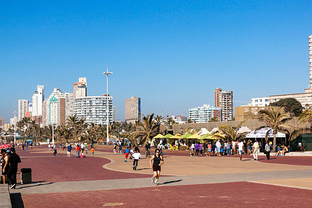 pessoas a caminhar na praia na frente do baile de finalistas - africa african descent south bicycle imagens e fotografias de stock