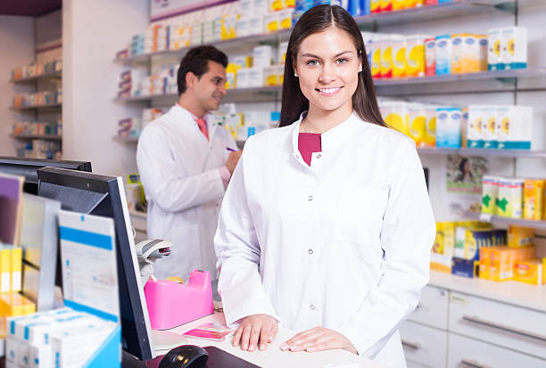 pharmaceutists na recepção da farmácia pronto para ajudá-lo - women customer service representative service standing - fotografias e filmes do acervo