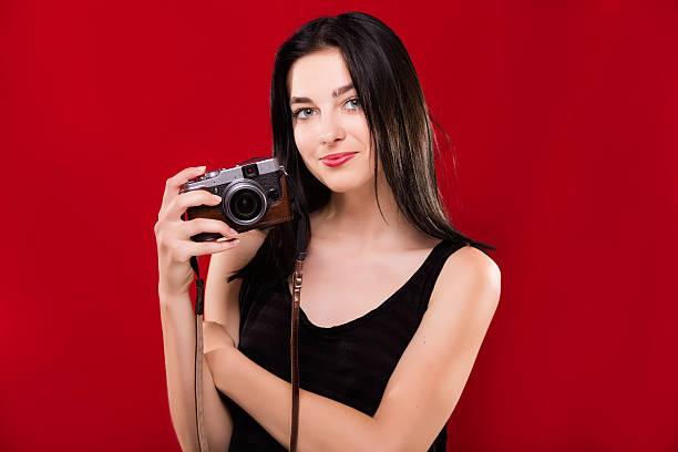 istock Cute young girl holding retro camera in her hand 543584210