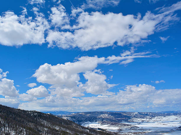 Mountain Peak and Ridgeline in the Lost River Range of Idaho with a cloud filled blue sky.