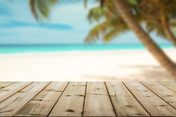 istock wood table top on blurry blue beach background 543587798