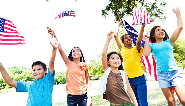 grupo de crianças acenam bandeiras norte-americanas desfile do dia da independência - parade flag child patriotism - fotografias e filmes do acervo