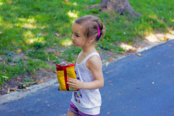 Child and Junk Food. Young Girl Eating Potato Crisps. Crisp Monster