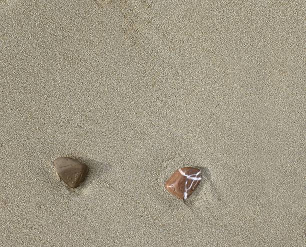 istock Sand background with two small sea pebbles 543596394