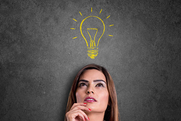 istock Woman looking at glowing light bulb over her head 543597096