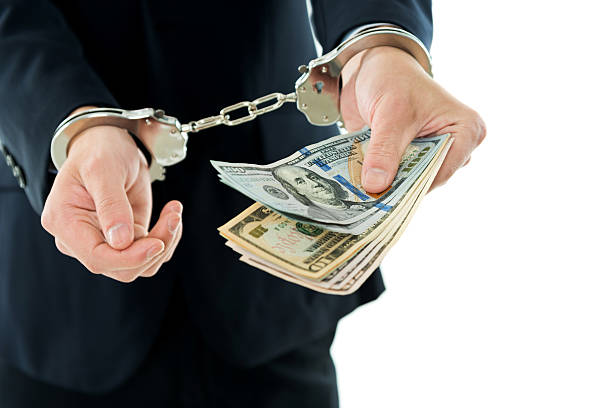 istock Businessman hands in handcuffs holding US dollars 543600330
