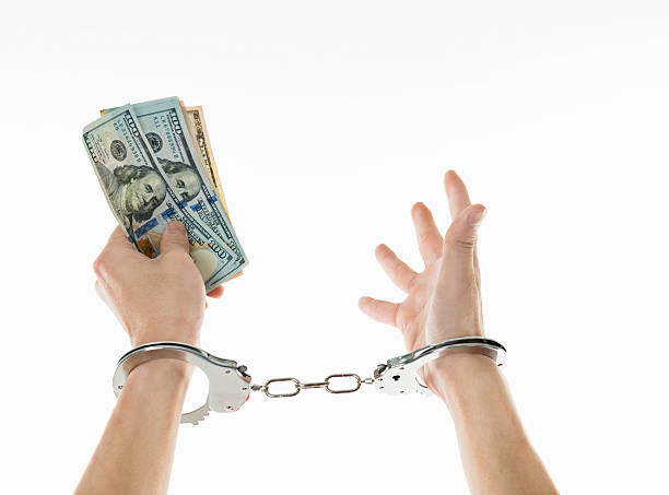 istock Businessman hands in handcuffs holding US dollars 543652116