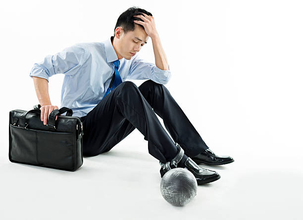 istock Businessman with ball and chain against white background 543653040