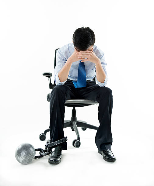 istock Businessman with ball and chain against white background 543653200