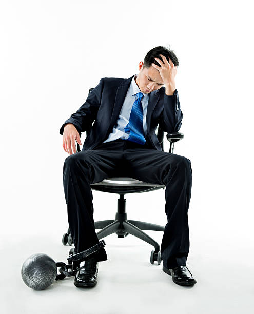 istock Businessman with ball and chain against white background 543653286