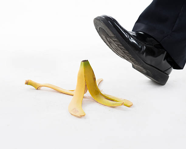 Businessman stepping on banana skin Businessman stepping on banana skin. slapstick comedy stock pictures, royalty-free photos & images