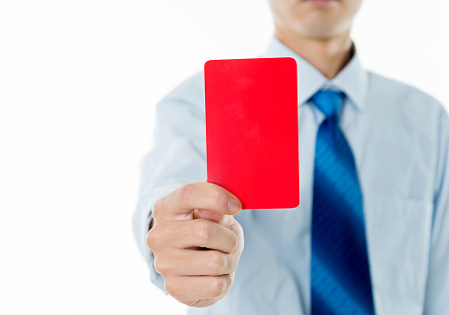 Young businessman holding red card against white background.