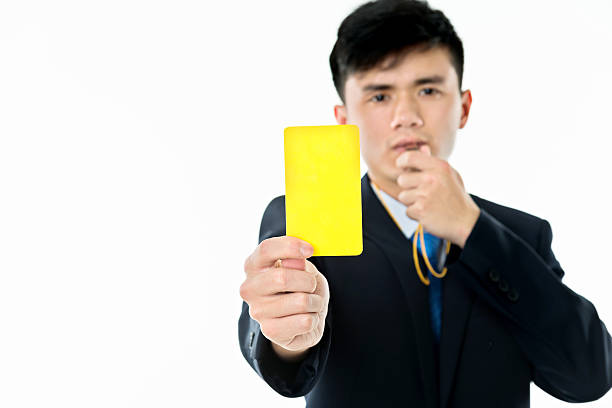 Referee holding red card and whistle on white background, closeup