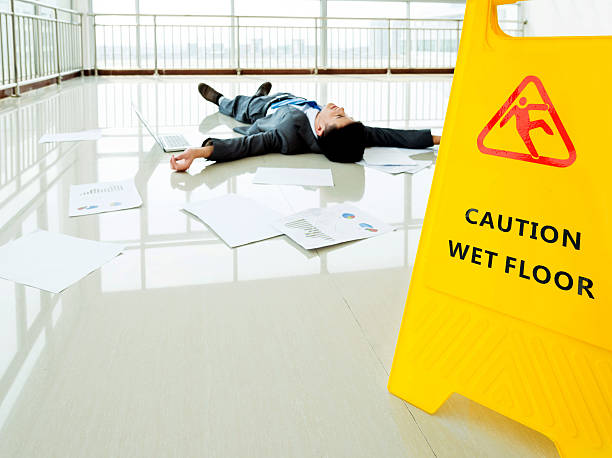 istock Businessman slipped on a floor next to caution sign 543661924