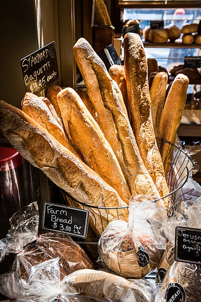 Baguettes by a windowsill in a bakery with sunlight Baguettes in early morning sunlight by a windowsill in a bakery with other breads bread bakery baguette french culture stock pictures, royalty-free photos & images
