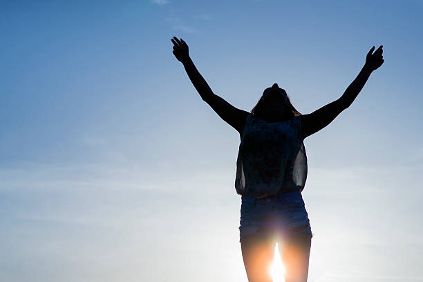 istock cheering woman open arms under sunrise 543662452